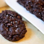 Close up of Vegan Double Chocolate Chip Cookies with more on a white tray in the background