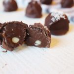 Paleo and Vegan Chocolate Truffles, one cut open in half with other whole ones surrounding it