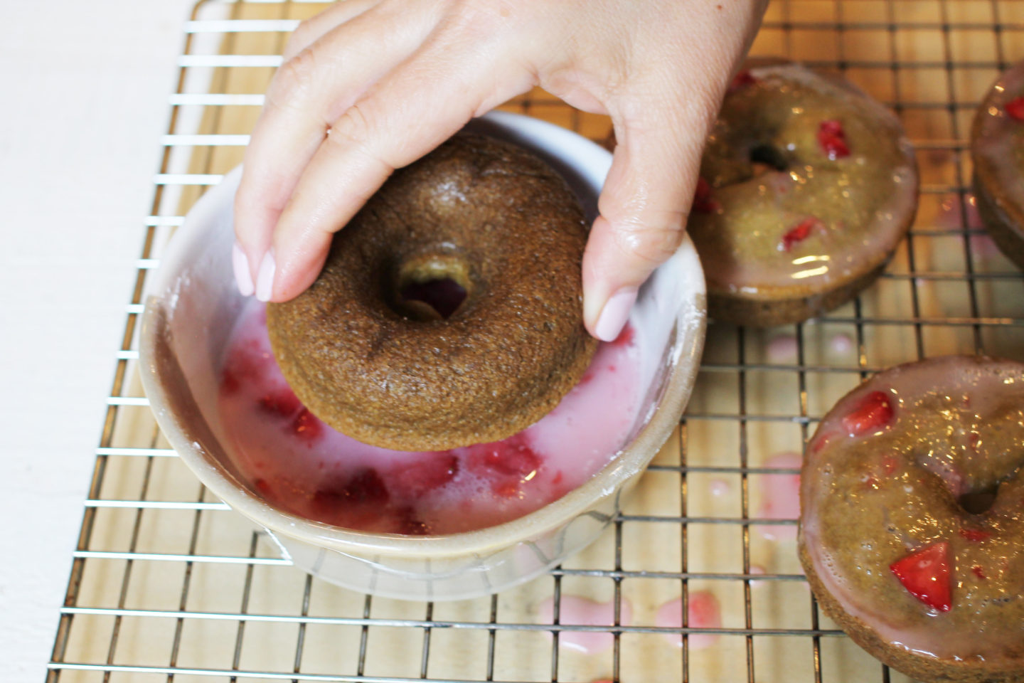 Dipping Donut in the Fresh Strawberry Glaze