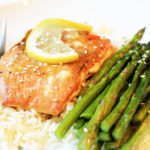 salmon on a plate with rice and asparagus