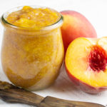 Peach and Ginger Jam in Jar with jam on spreader