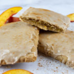 Homemade Peach and Ginger Pop Tarts stacked on each other with fresh Peach slices